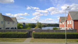 A residential area with houses along a river, a wooden fence, and a clear sky. - Mallard Cottage (Aylesford)