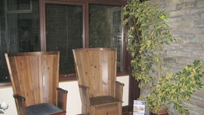 Two wooden chairs with drawers, a potted plant, and a stone wall. - Smithfield guesthouse (Dounby)