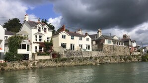 Ein Ufergrundstück mit Steinmauern und Häusern am Fluss.