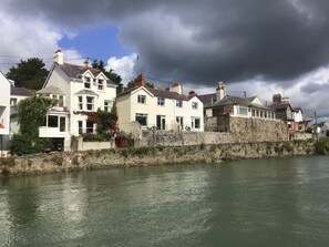 Ein Ufergrundstück mit Steinmauern und Häusern am Fluss.