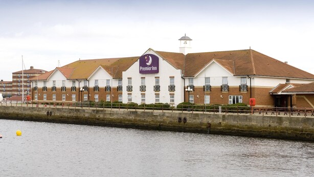 A hotel with a prominent sign, a brick facade, and a waterfront view.