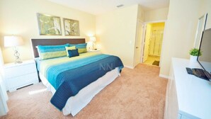 A bedroom with a bed, nightstands, a desk, and a shower area. - Private Pool - Cozy Vacation Home  Near Disney! (Davenport)