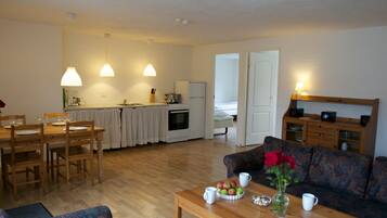 A compact living space with a dining area, kitchen, and seating area.