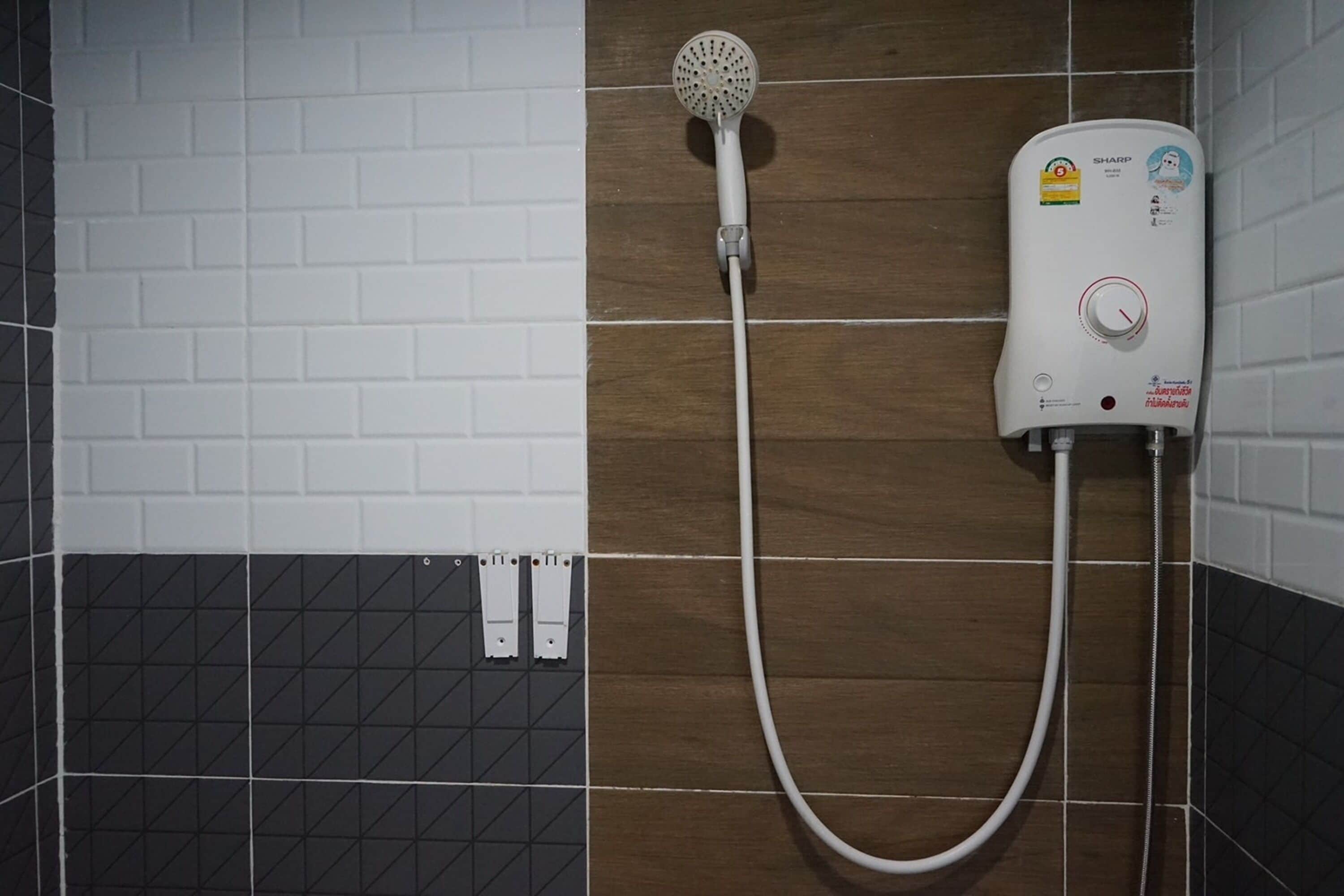 Ducha con cabezal de ducha de mano y panel de control en la pared.