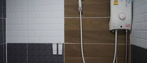 Ducha con cabezal de ducha de mano y panel de control en la pared.