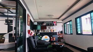 Un interior moderno con una barra de café, un sofá y una escalera que sube a otro nivel.