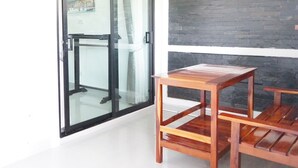 Una habitación con puerta de vidrio que da a vistas de la ciudad, una mesa de madera y una pared de piedra.
