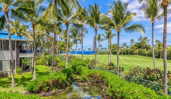 A tropical resort with a pool, palm trees, and a view of the ocean. - Aloha Condos, Mauna Loa Village, Condo 11-70, Fairway View, AC (Kailua-Kona)