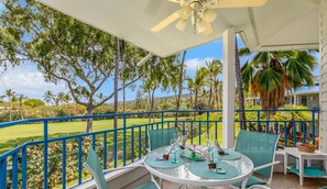 Enjoy a tranquil meal or relaxing moment in this serene outdoor seating area overlooking a lush landscape and golf course.