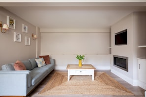 Relax in this stylish living room with a sofa, coffee table, and flat-screen TV.