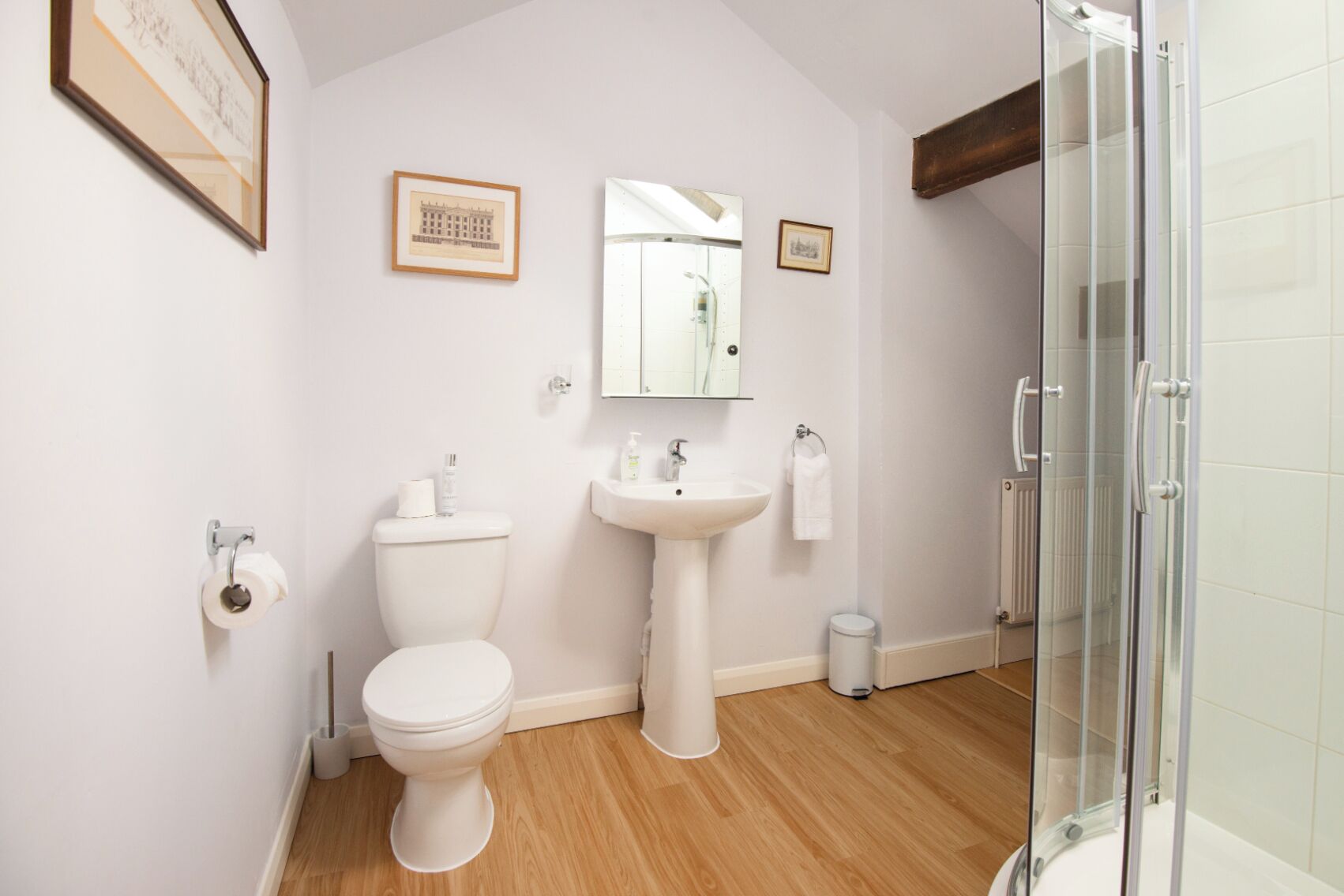 Une salle de bain moderne équipée de toilettes, d’un lavabo et d’une douche à parois de verre.