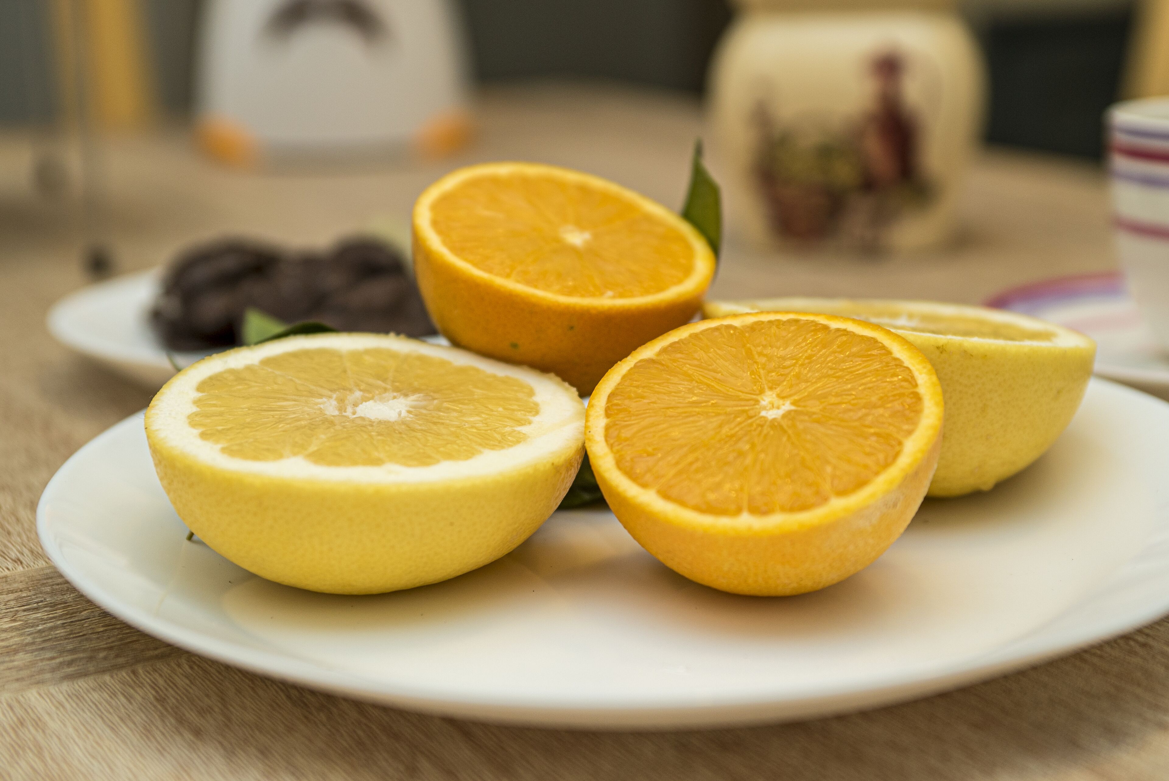 A plate with four orange slices and a whole orange on a white plate.