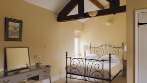 Une chambre à coucher avec un lit, une commode, un miroir et une fenêtre.