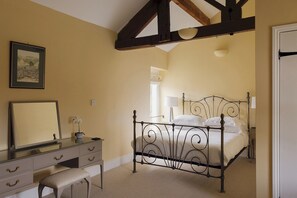 Une chambre à coucher avec un lit, une commode, un miroir et une fenêtre.