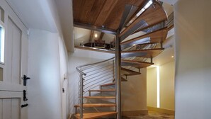 A spiral staircase with wooden steps and metal railings, leading to an upper floor. - Rye Croft Cottage on the Chatsworth Estate (Edensor)