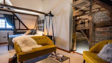 Camera da letto moderna in stile loft con un letto, un divano e un caminetto a parete di vetro.