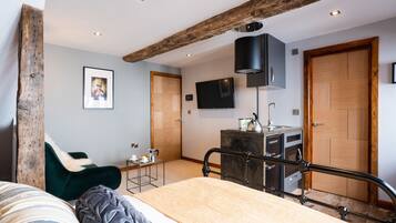 Un dormitorio moderno con una cama, un escritorio, una silla, un televisor y una puerta de madera.