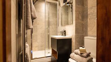 Un bagno moderno con box doccia in vetro, lavandino e servizi igienici.