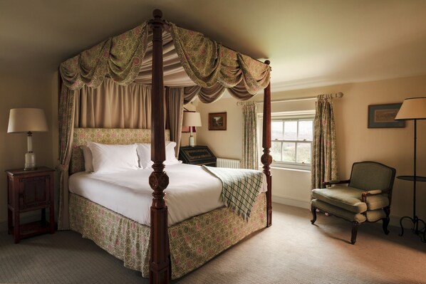 A four-poster bed with a canopy, a chair, a nightstand, a lamp, and a window with curtains. - Stank House Farm, Bolton Abbey (Bolton Abbey)