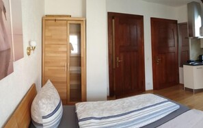 Une chambre à coucher avec un lit, une armoire et deux portes.