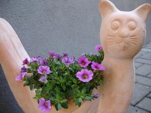 Un pot en forme de main orné de fleurs violettes.