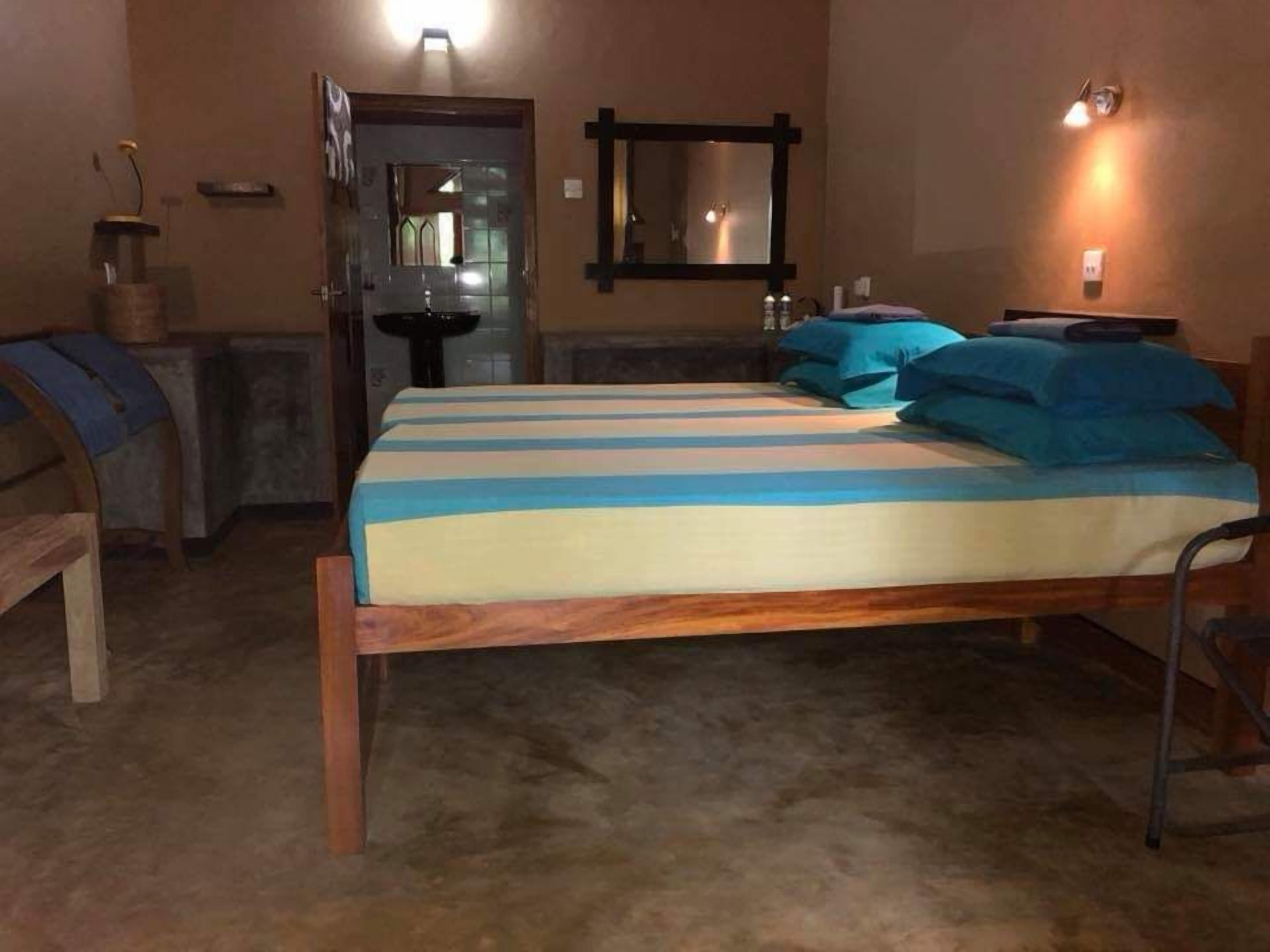 A bedroom with a wooden bed, a mirror, and a nightstand.