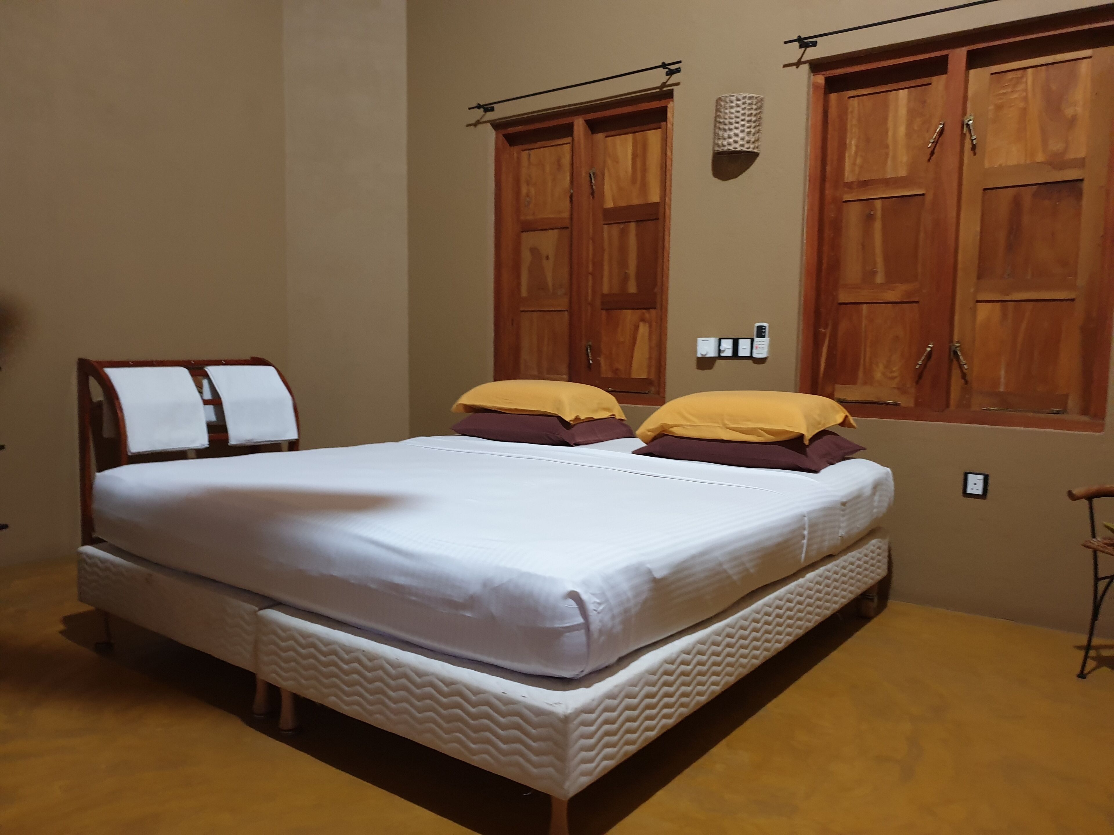 Un dormitorio con cama, armario de madera y lámpara de pared.