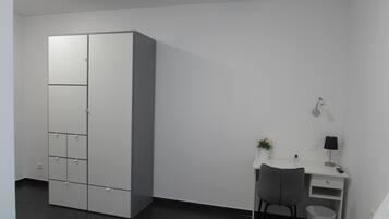 Une chambre à coucher moderne avec un lit, un bureau et une armoire.