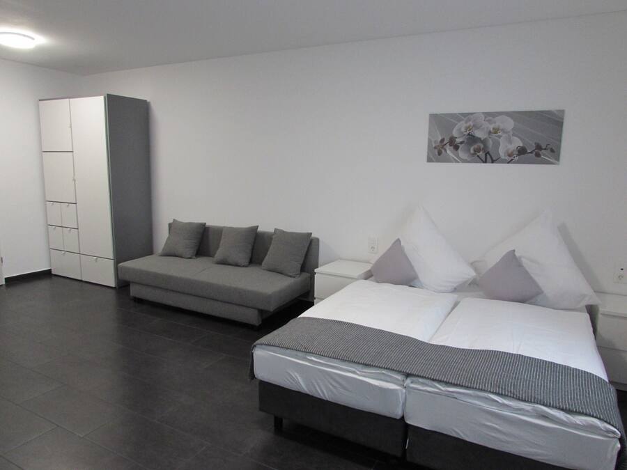 Un dormitorio con cama, sofá y armario.