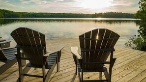 A wooden deck with two Adirondack chairs facing a calm lake. - Carpe Diem Sunset View (Mactier)
