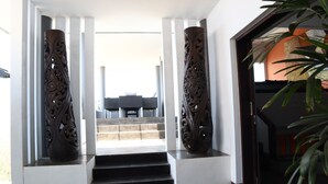 A staircase leading to a balcony with a view, flanked by two ornate wooden columns. - The Bukit Ocean View Villa Jimbaran (Jimbaran)
