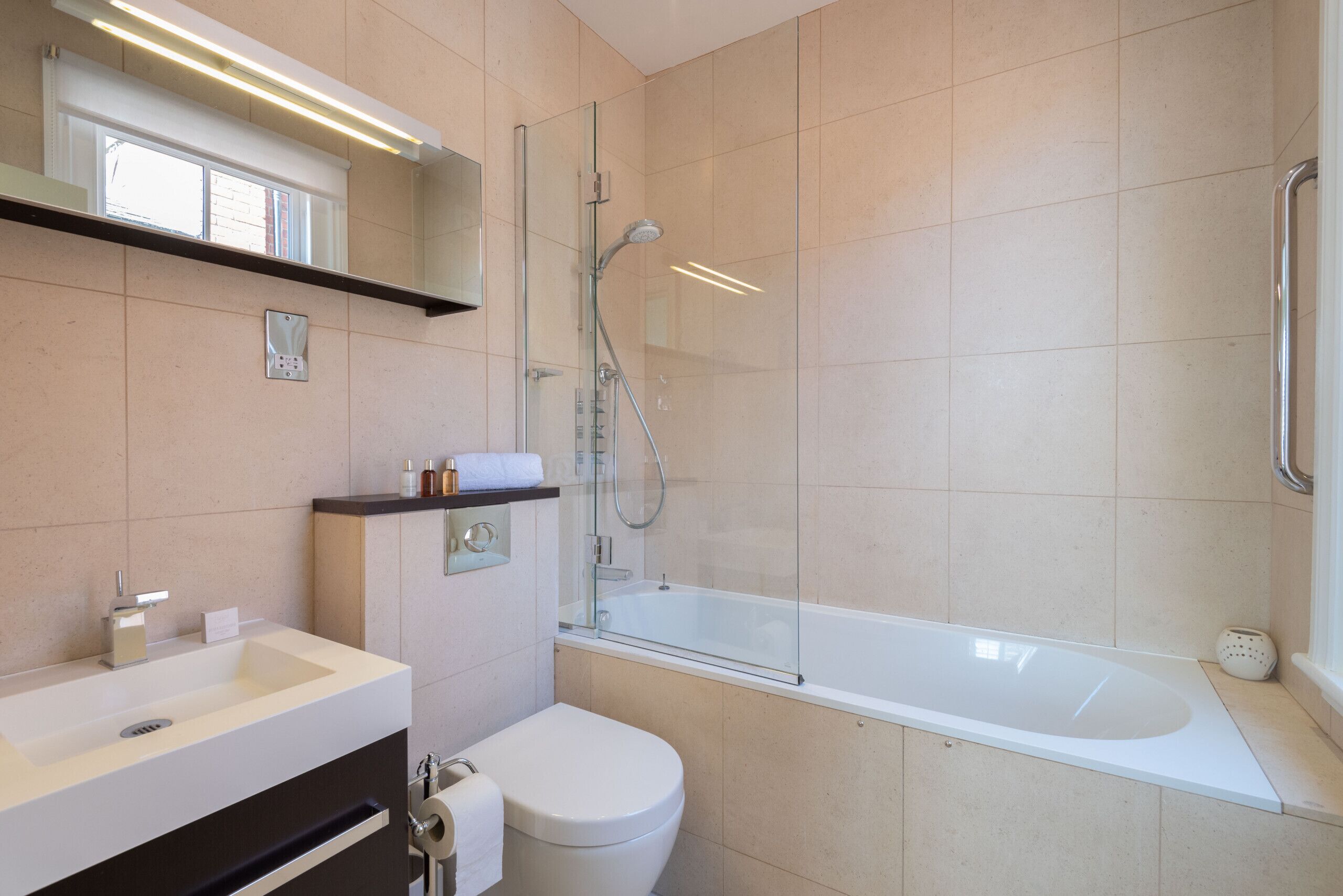 Une salle de bain moderne avec une douche à parois de verre, une baignoire blanche et des toilettes blanches.