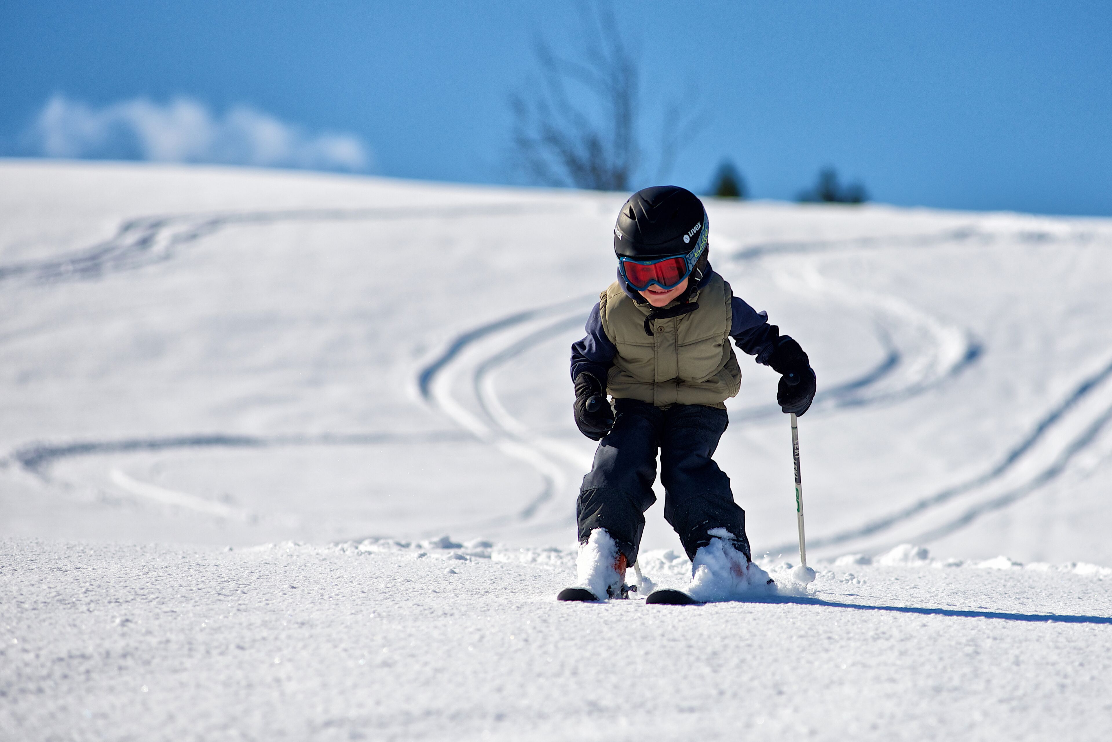 Un enfant fait du ski sur une pente enneigée.