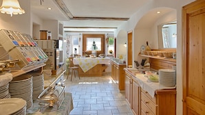 Una cocina con una mesa de madera, una cafetera y diversos utensilios de cocina.