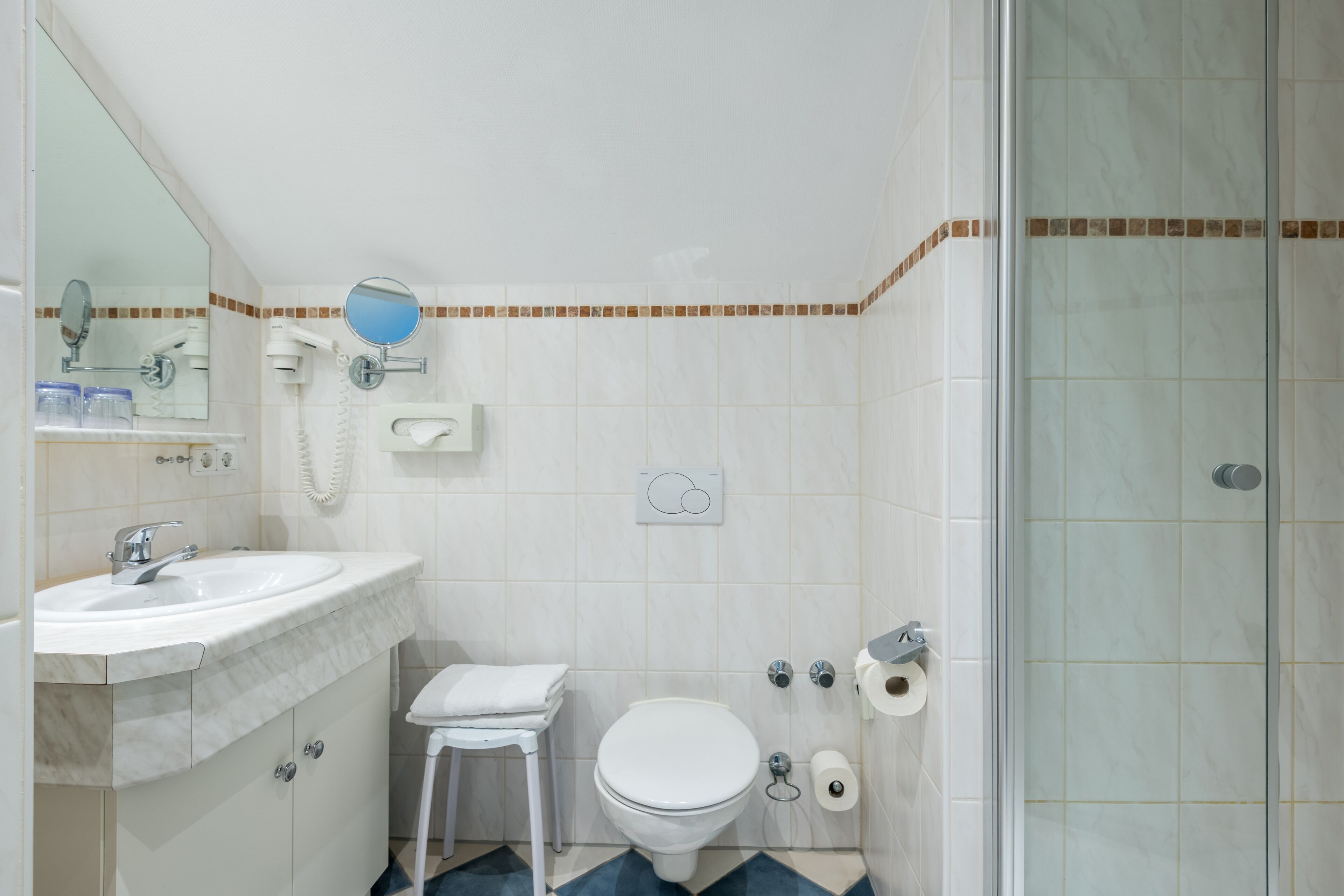 A bathroom with a sink, toilet, and shower.
