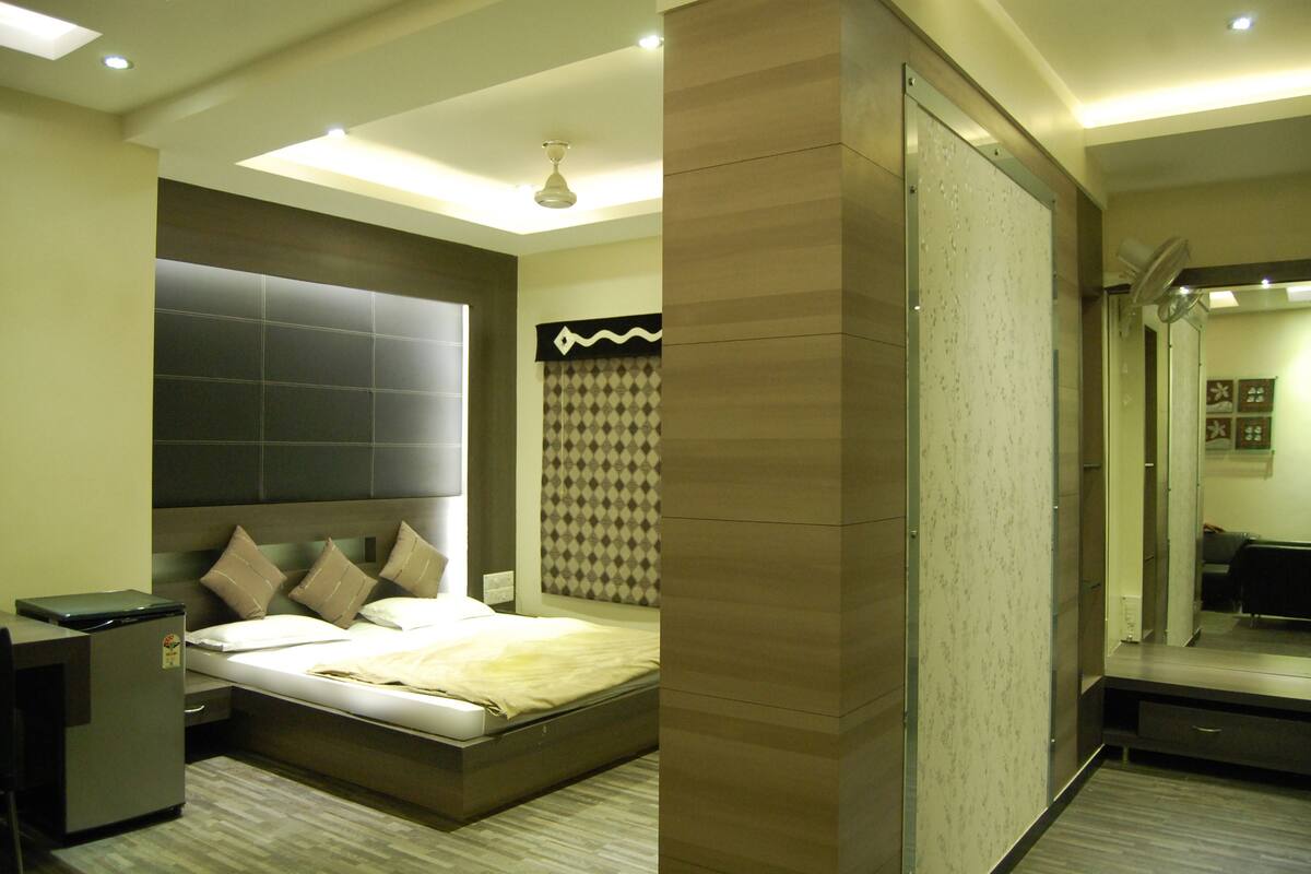 Un dormitorio moderno con cama, escritorio y espejo.