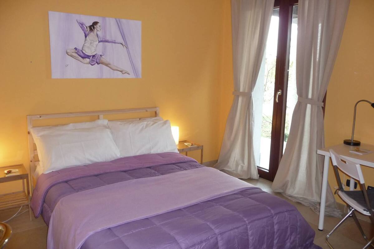 Un dormitorio con cama, escritorio y silla.