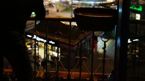 A person overlooking a cityscape at night, with a view of illuminated buildings and a dome structure. - Bulgakoff Hostel (Kyiv)