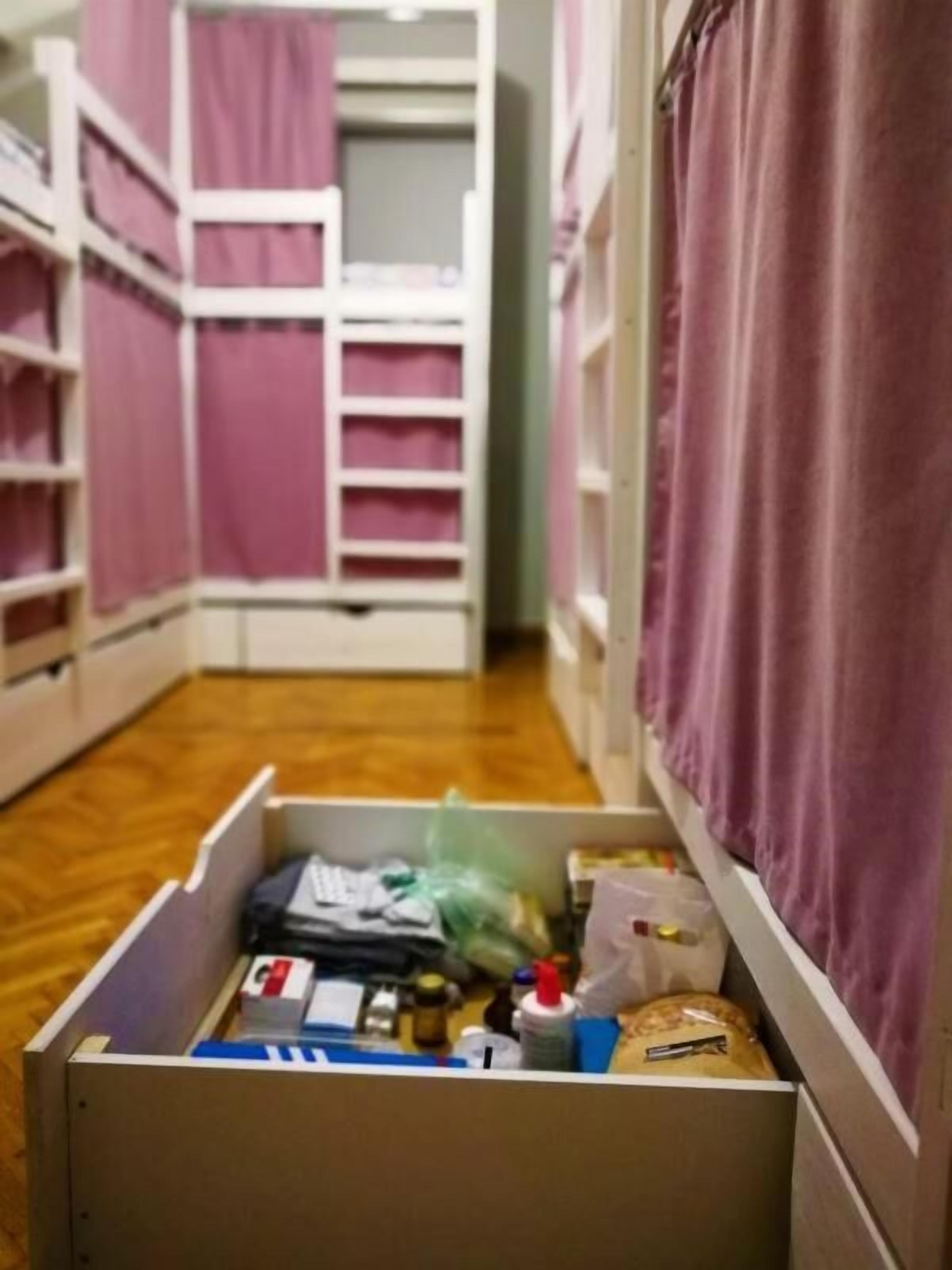 A storage area with shelves and a drawer containing various items.