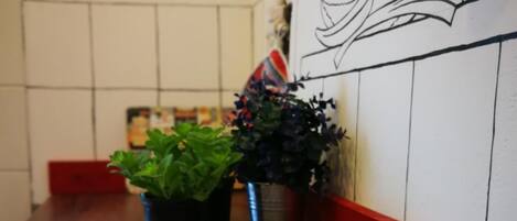 Un tazón de sopa sobre una mesa de madera, con macetas con plantas en el fondo.