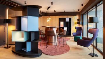 A modern interior with a central round table, multiple chairs, and a unique geometric floor lamp.