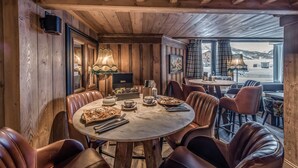 Un'accogliente zona pranzo con pareti in legno e un'ampia finestra che si affaccia sulle montagne.