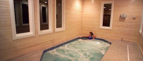 Een kamer met een houten inrichting, een bubbelbad en een raam met uitzicht.