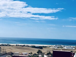 A coastal view with buildings, a beach, and the sea.