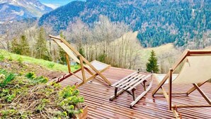 A wooden deck with outdoor furniture, overlooking a mountainous landscape. - Heidi Chalet Alps - Unique Experience - Authentic Part (Rossinière)