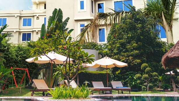 A hotel named The Shoba Estate Gold with a swimming pool, lounge chairs, and tropical landscaping. - The Shoba Estate Gold (New Delhi)