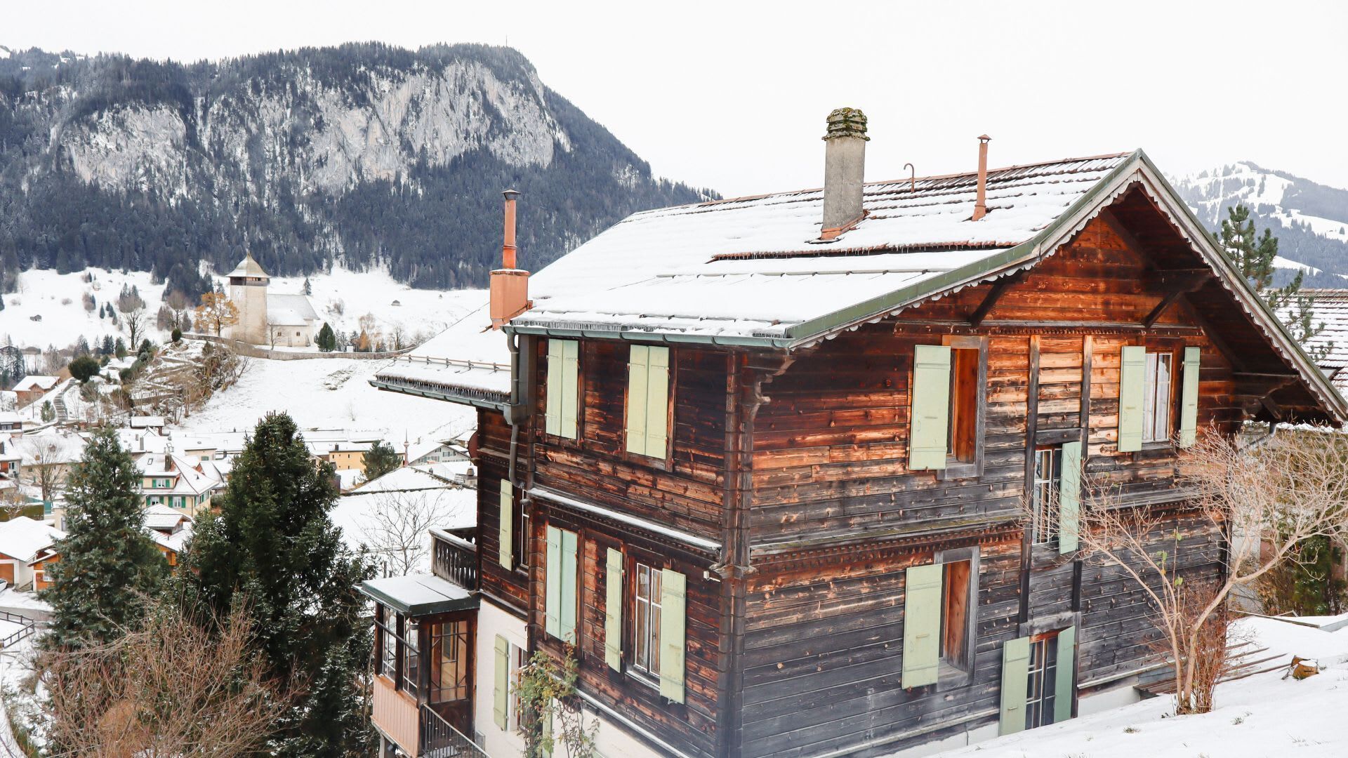the chalet surrounded by the snow covered town 