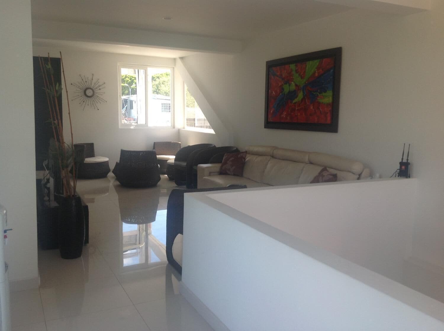 Ein modernes Wohnzimmer mit einer Couch, einem Couchtisch und einem großen Fenster.