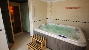 A bathroom with a hot tub, a wooden stool, and a towel rack. - Guest House Vila Alexandar (Palic)