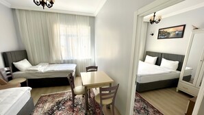 Una habitación de hotel con cama, escritorio, silla, alfombra y un cuadro en la pared.